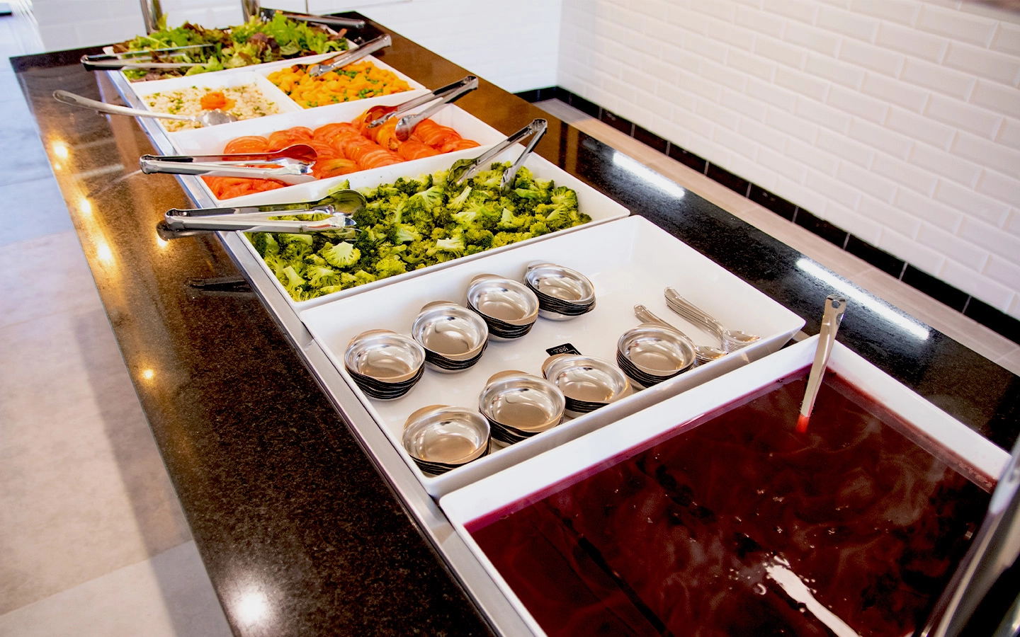 Buffet com variedade de saladas e sobremesa.